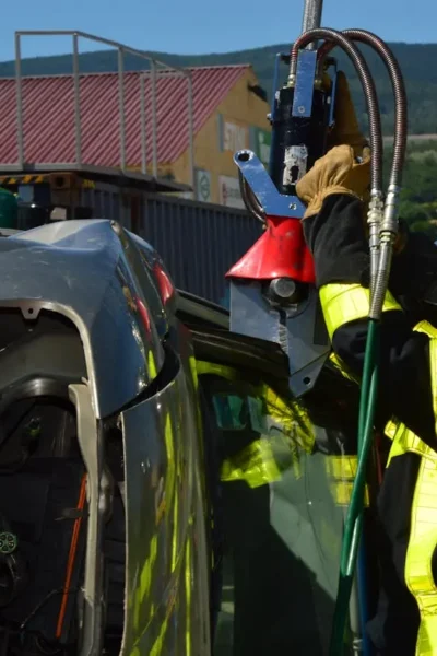 Bombeiros resgatando vítima de sinistro de trânsito em veículo capotado, ilustrando quanto custam os sinistros de trânsito em termos de recursos de emergência e impacto humano.