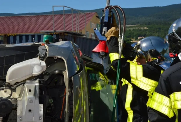 Bombeiros resgatando vítima de sinistro de trânsito em veículo capotado, ilustrando quanto custam os sinistros de trânsito em termos de recursos de emergência e impacto humano.